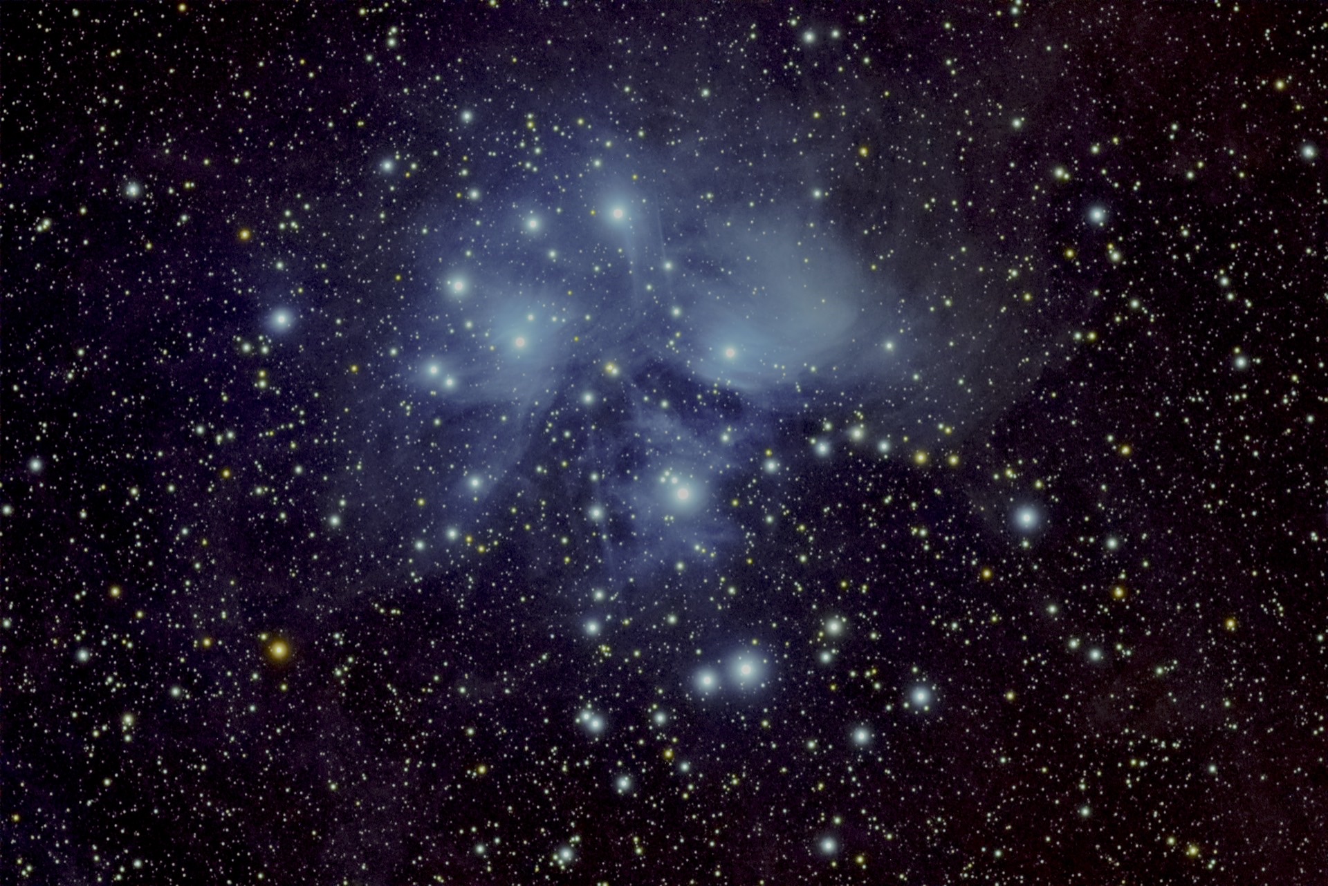 The Pleiades, bright blue stars wrapped in pale reflection nebulosity.